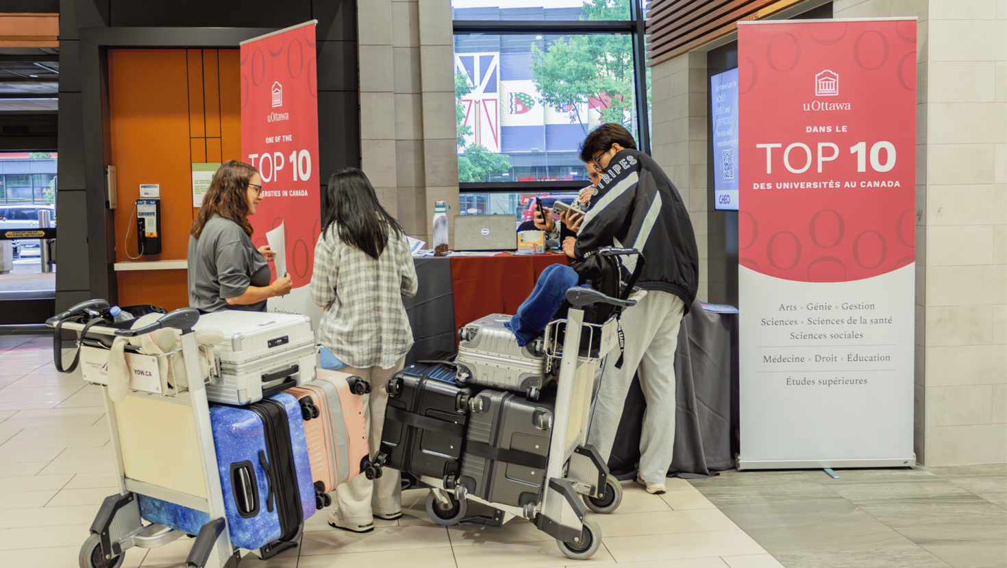 Personnel de l'Université d'Ottawa en train d'accueillir des nouveaux étudiants à l'Aéroport international Macdonald-Cartier d’Ottawa.