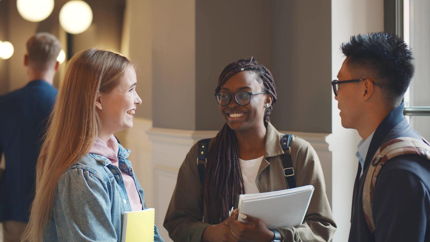 Trois étudiantes et étudiants discutent après les cours.