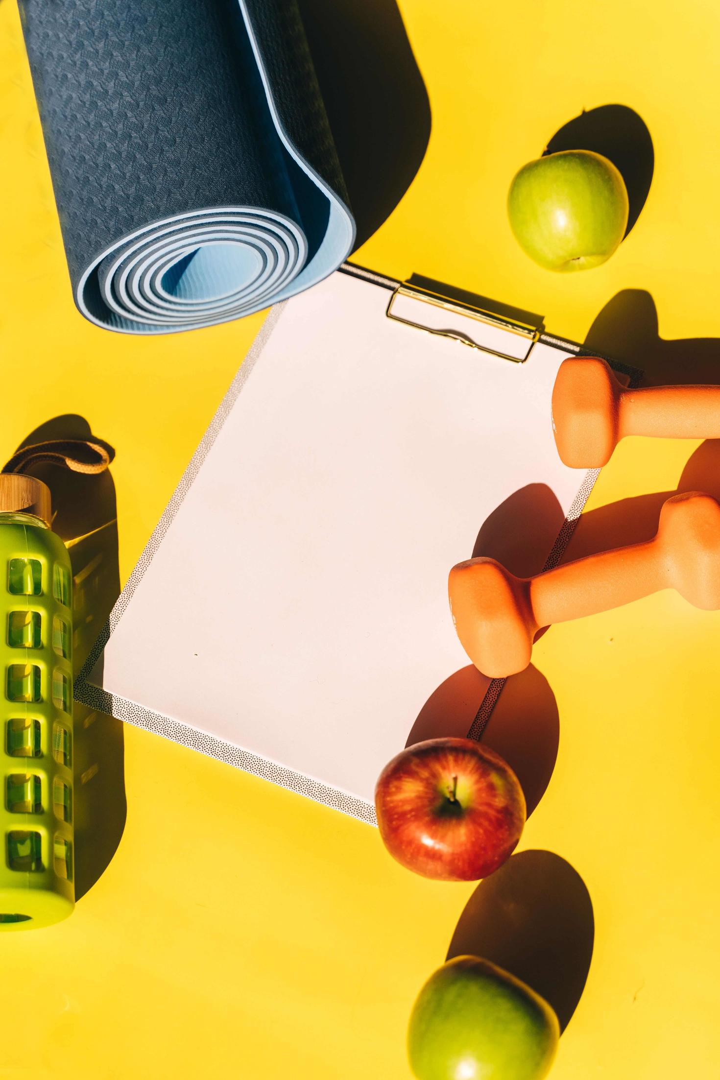 Tapis de yoga, pommes, bouteille d’eau, presse-papiers